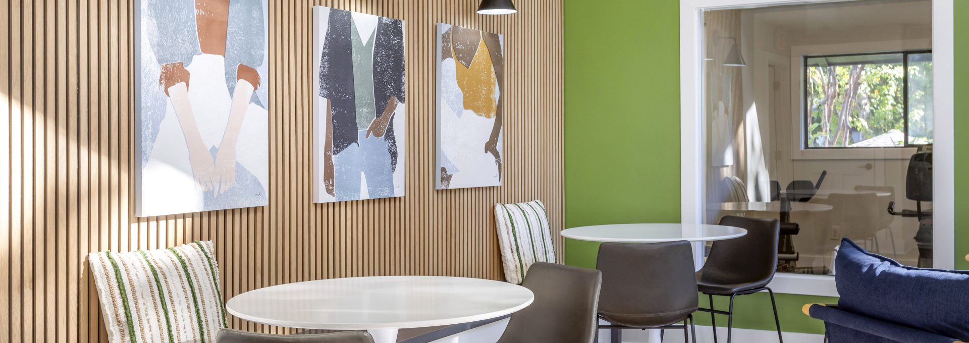 a modern dining area with green walls and white furniture at The Terra at Norcross
