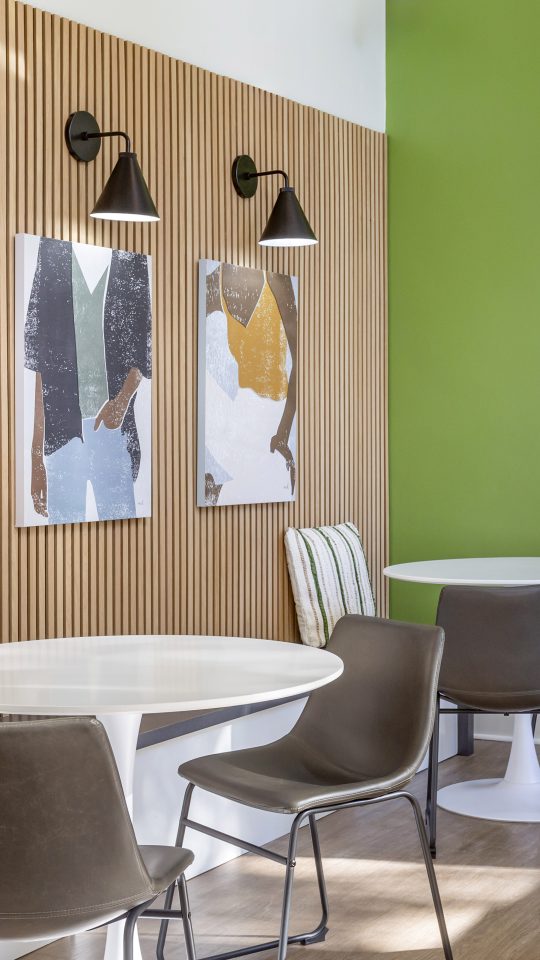 a modern dining area with green walls and white furniture at The Terra at Norcross